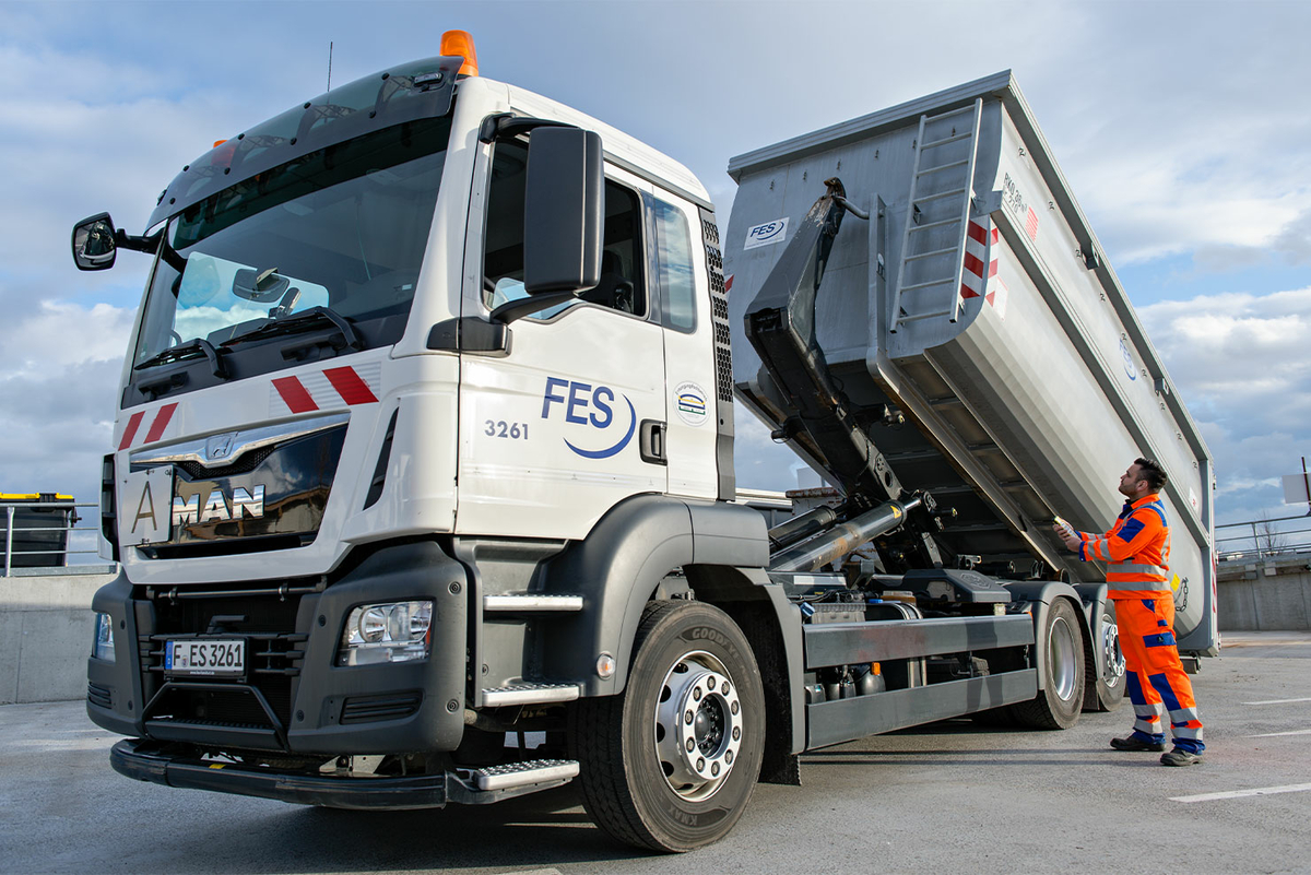 FES-LKW beim Entladen mit Mitarbeiter in Orange